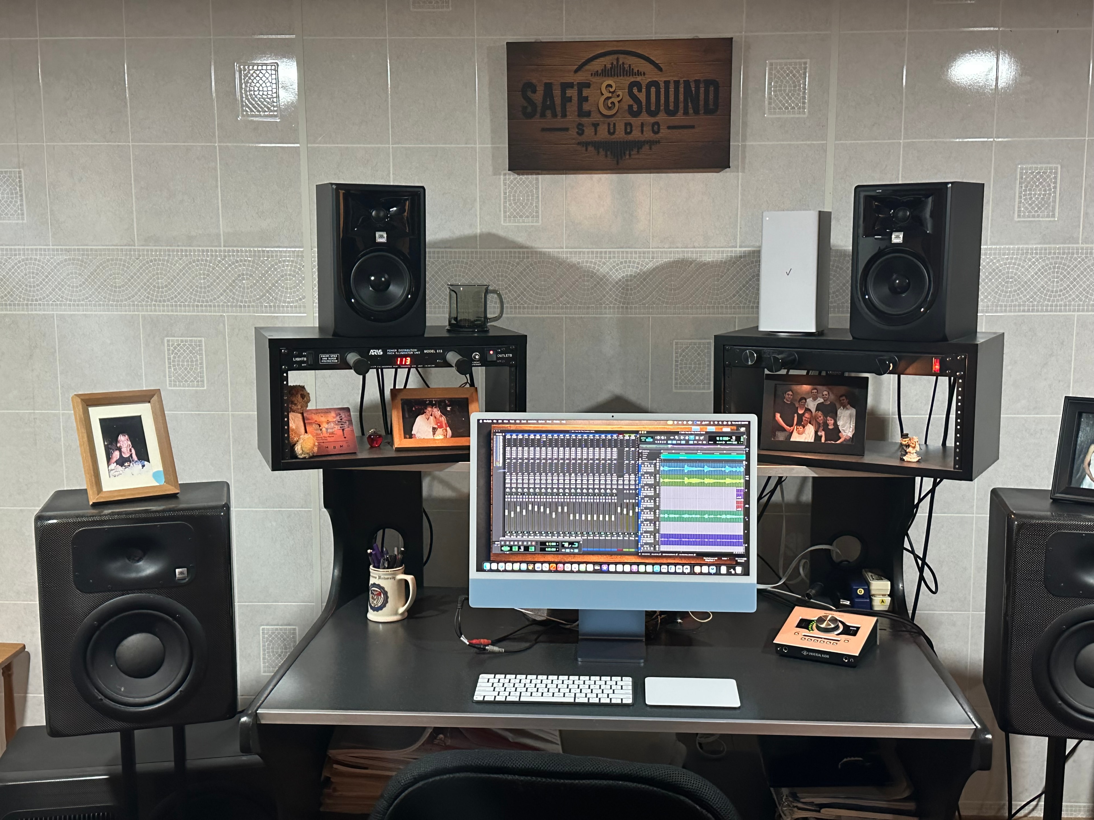 Recording desk with JBL monitors, iMac running Pro Tools, and Safe and Sound Studio sign